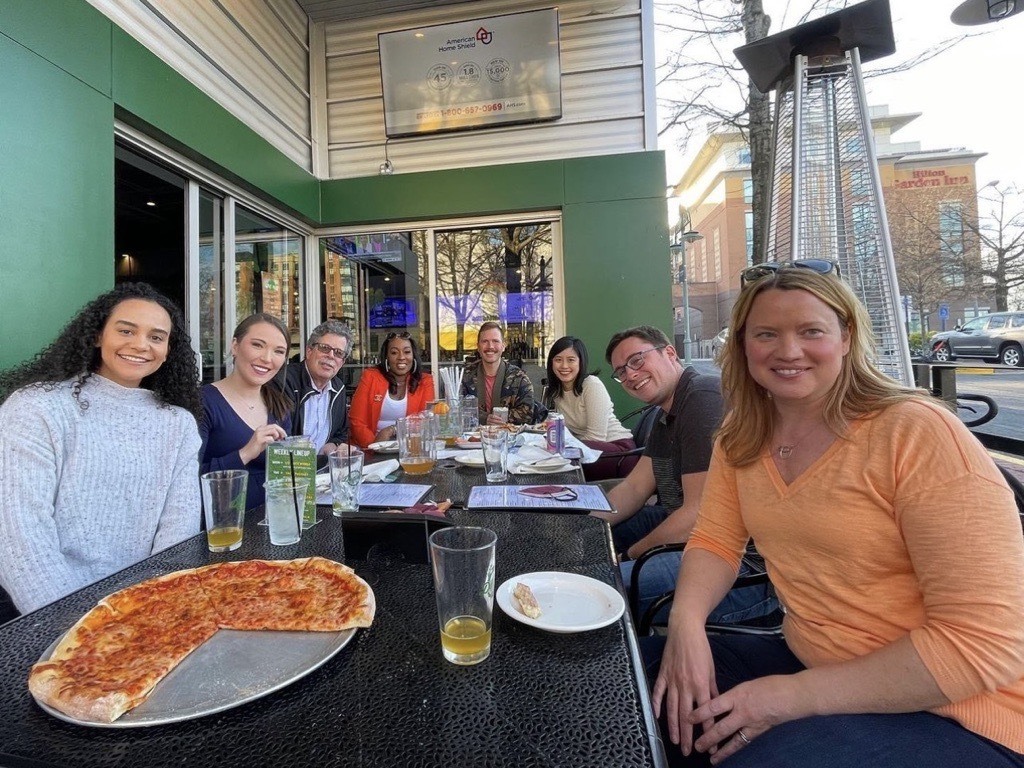 A group of FMP employees having pizza and drinks at a local restaurant/bar, Dudley's.