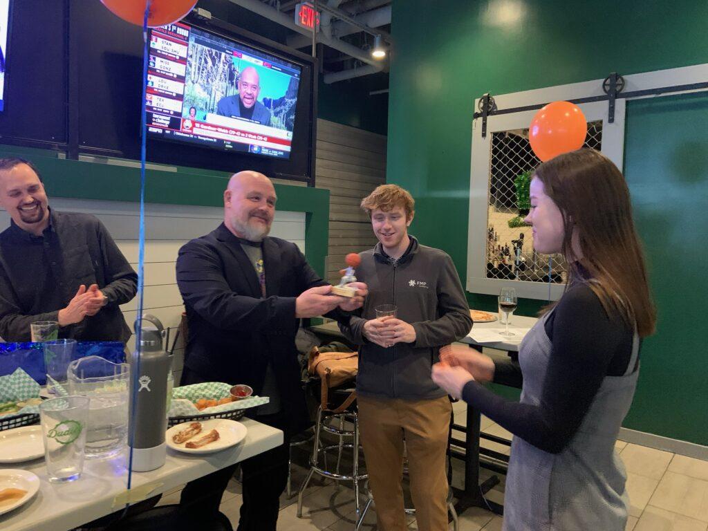 One of our coworkers receiving her award for winning March Madness!