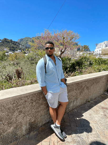 An Dom leaning against a ledge on a road in Italy.