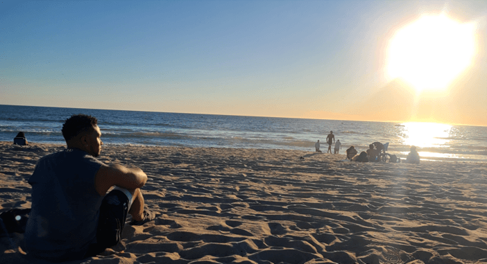 An image of Dom sitting on the beach.